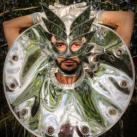 Sukha Forest - A man with with a silver mask with a silver shiny shoulder pads